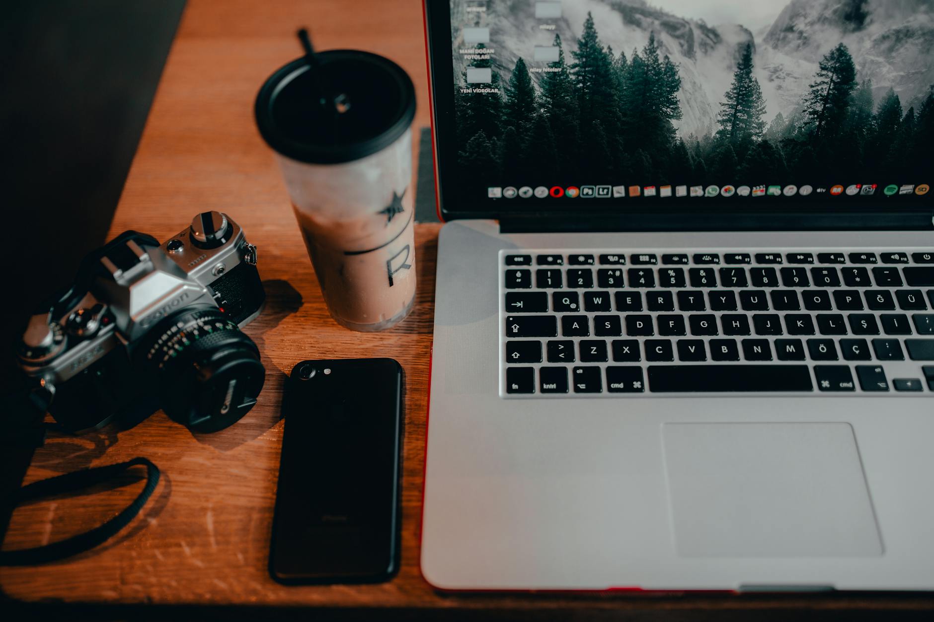 camera and electronic devices beside glass with beverage