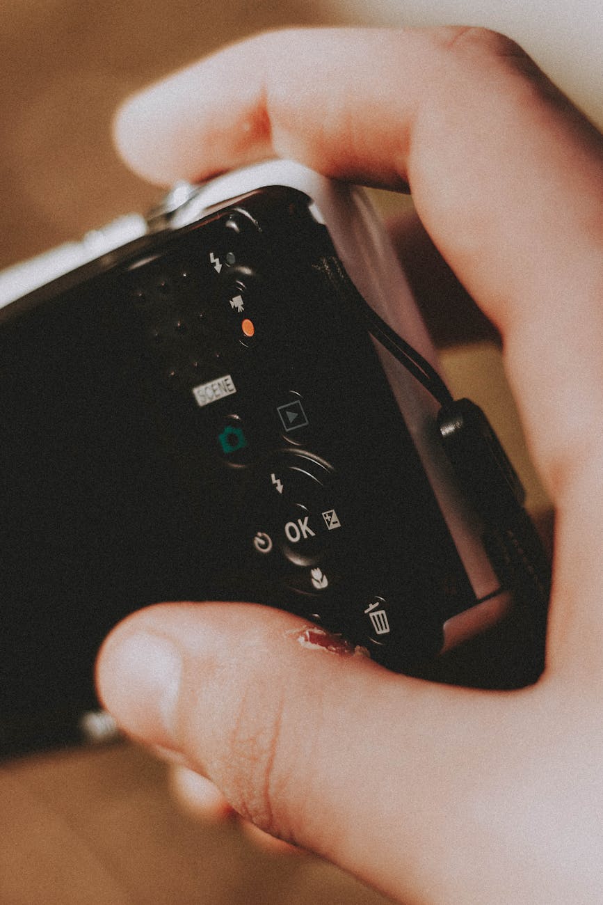 close up of a person holding a digital camera