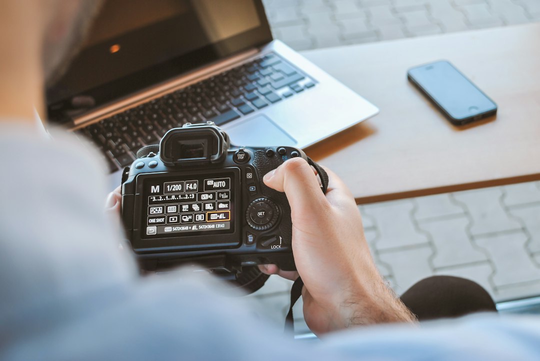 Photographer reviewing their work with a camera, reflecting on the middle stage of learning photography