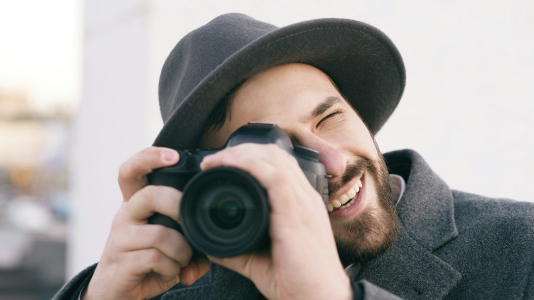 Photographer smiling while shooting with a camera, capturing the joy of picking up photography again